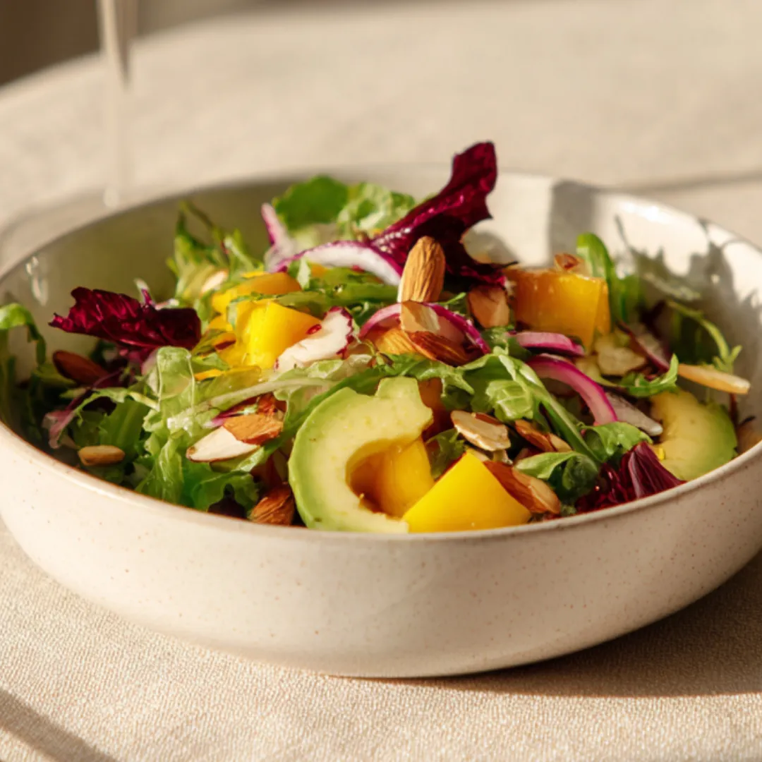 salade roquette avocat mangue servie dans une assiette estivale