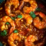 Crevettes Pil-Pil épicées servies avec de l'ail et du piment