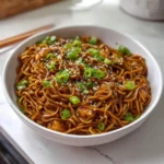 Recette de poulet aux nouilles à l’ail collant, plat savoureux et réconfortant.