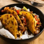 Tacos épicés au bœuf dans une assiette, garnis de légumes frais.